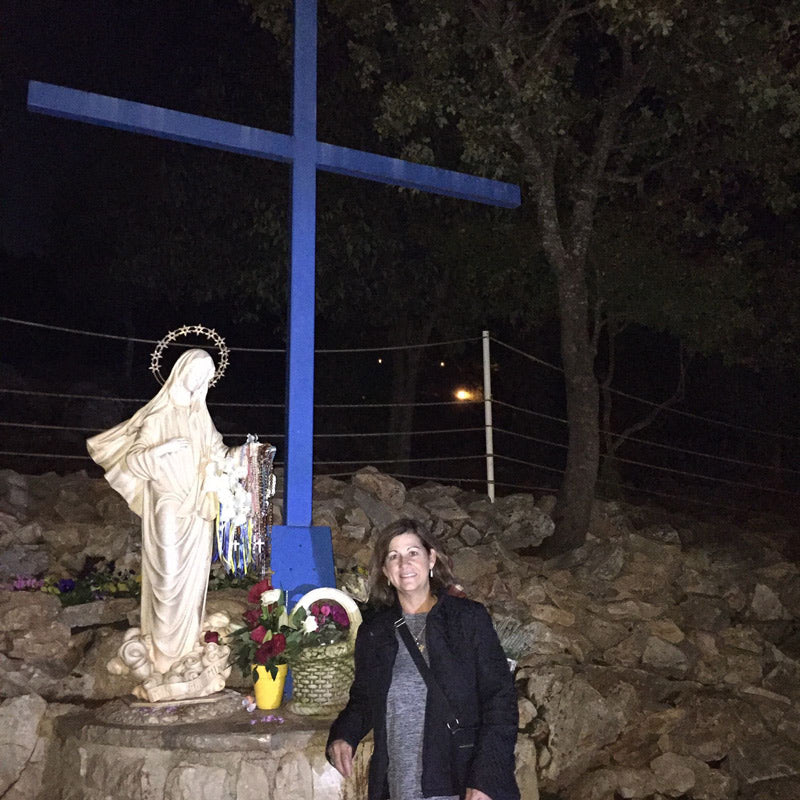 Pat in front of statue of Blessed Virgin and blue cross