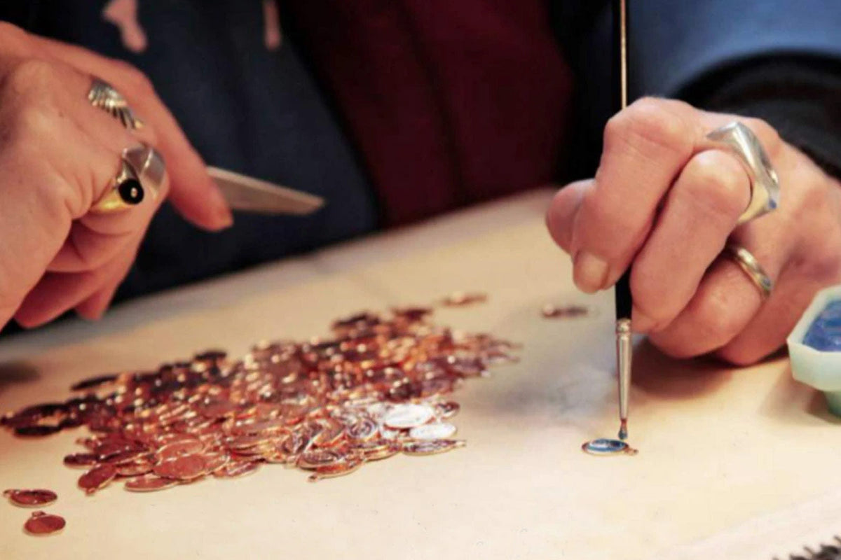 close up of enamel being applied to Miraculous Medals