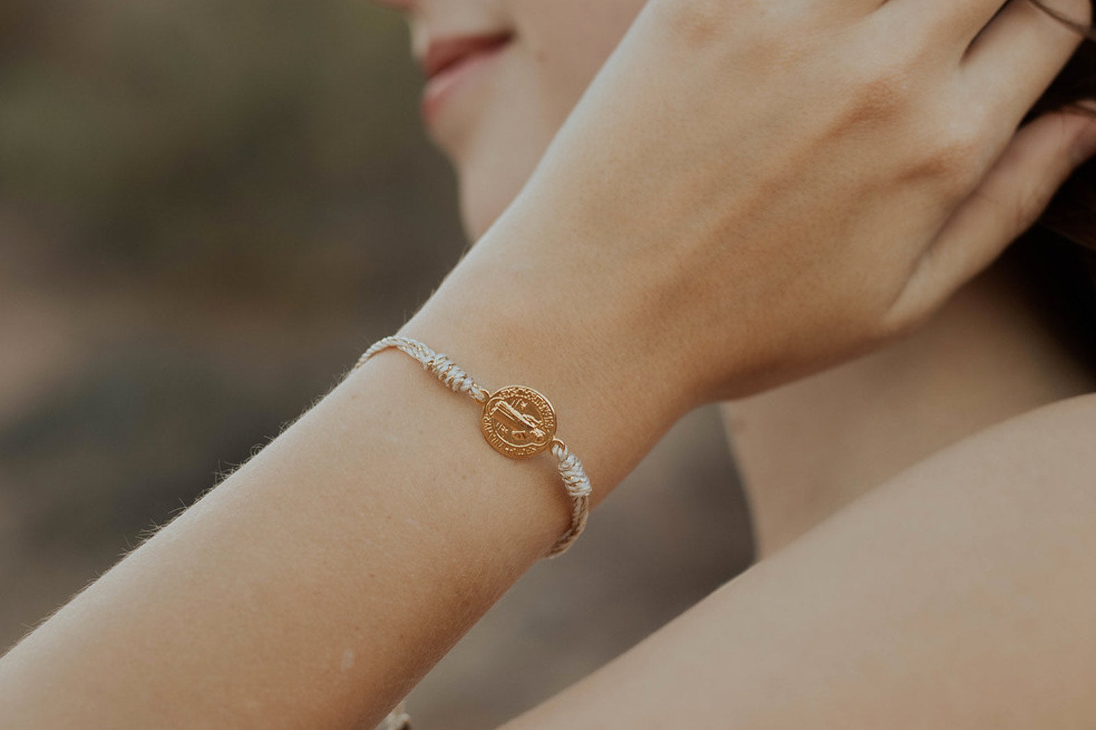 Woman wearing a My Saint My Hero Serenity Benedictine Blessing Bracelet in Gold