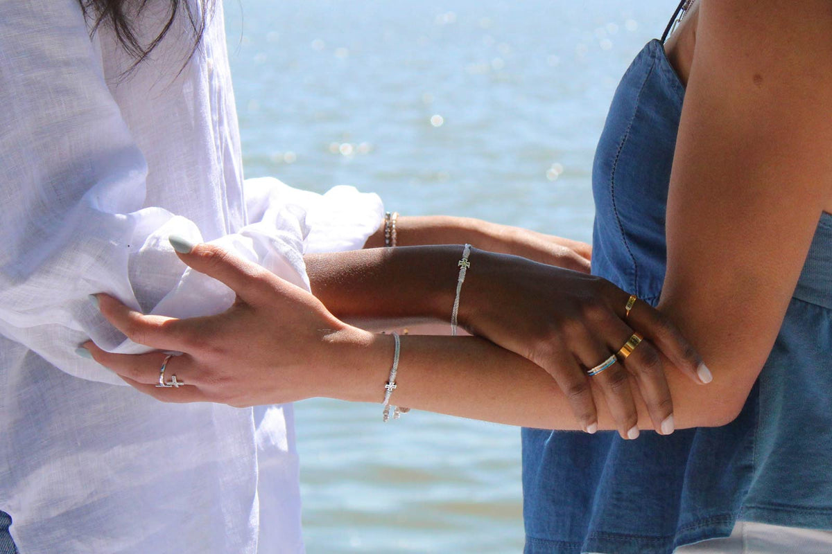 two women joined in prayer close up of arms