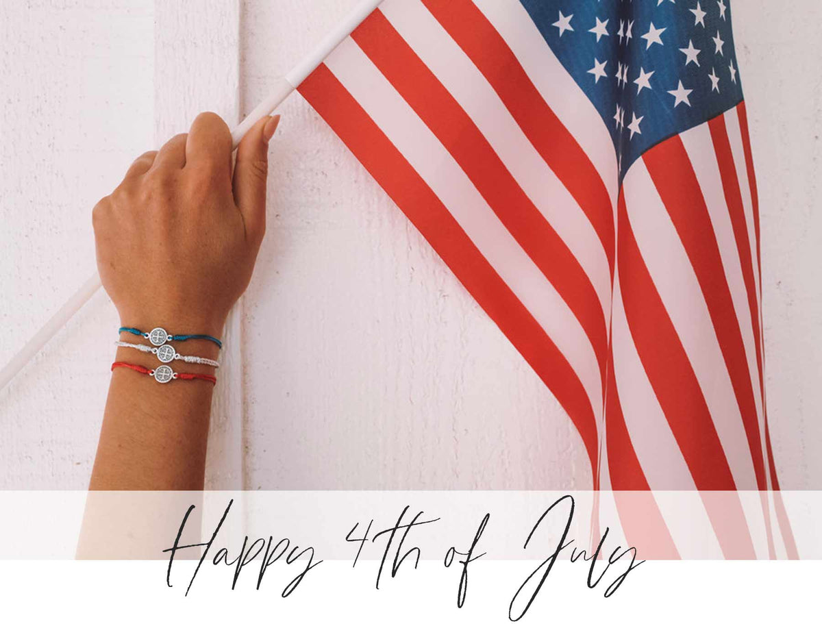 Hand wearing Red White Blue Blessing Bracelets Holding an American Flag