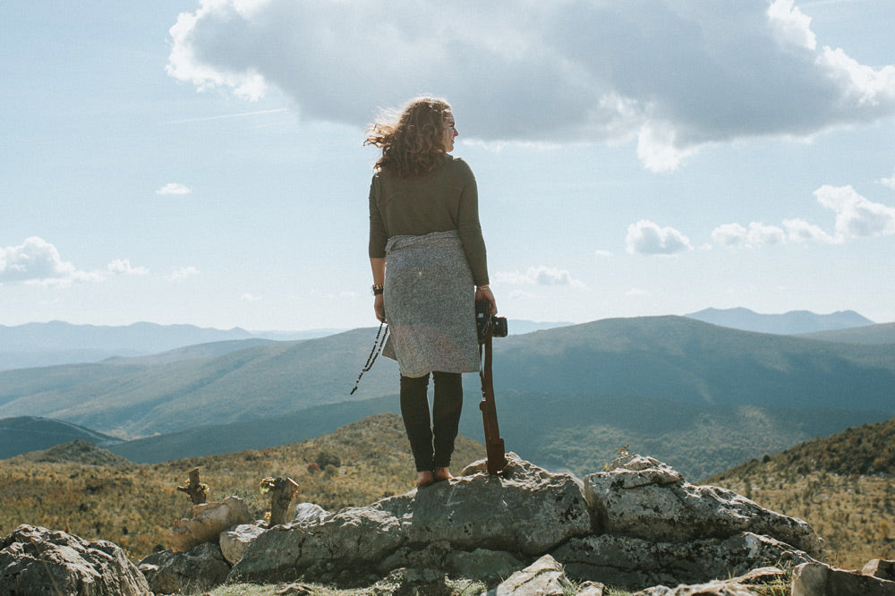 woman standing on a rise overlooking hills