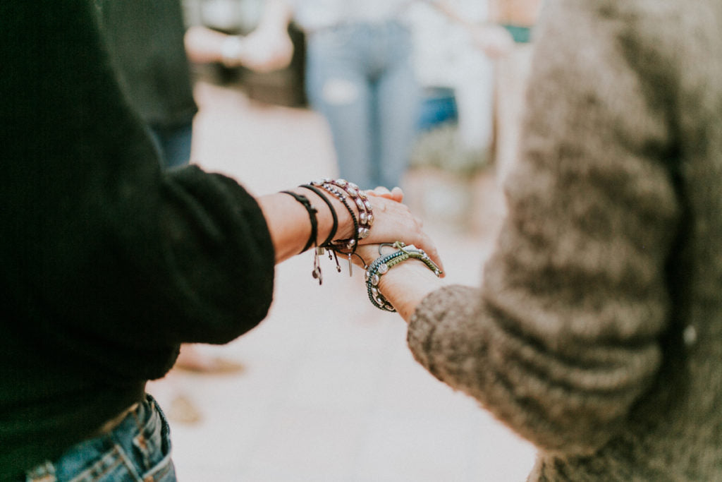 holding hands, arms adorned with prayer bracelets - mysainmyhero.com
