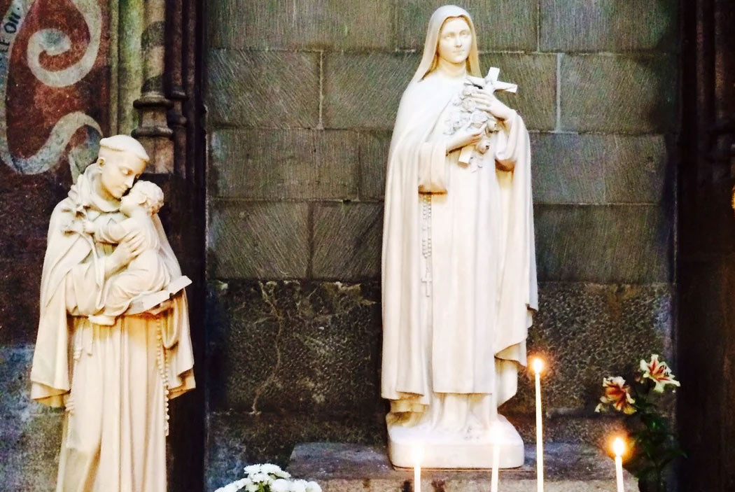 St. Therese of Lisieux and St. Anthony of Padua statues on a cathedral altar.