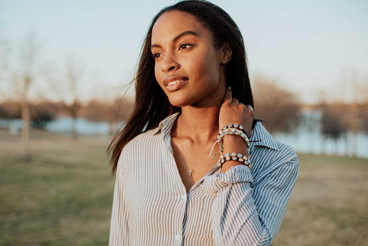 A woman wearing a stack of My Saint My Hero handwoven Benedictine Blessing Bracelets