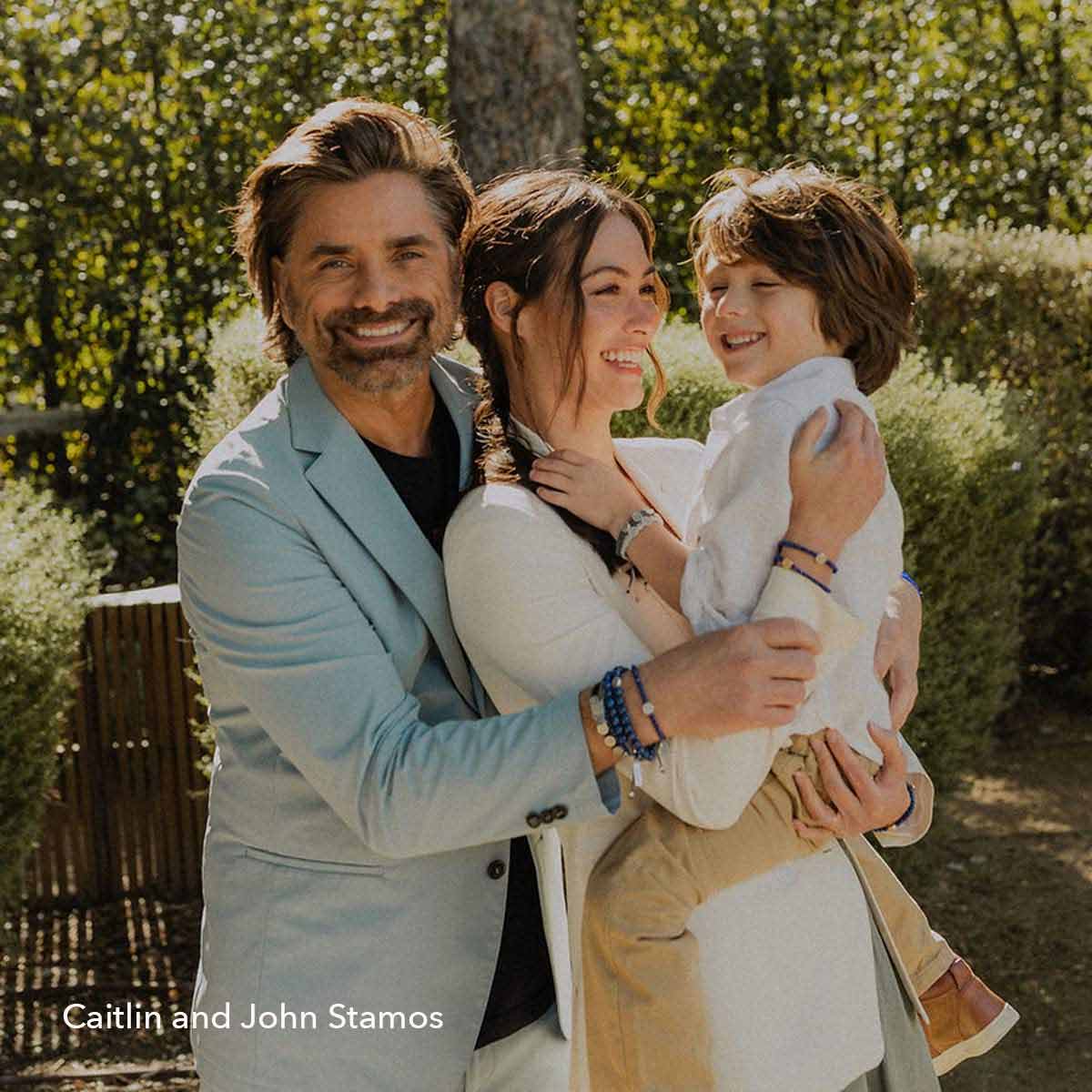 The Stamos Family smiling outside in the sunshine