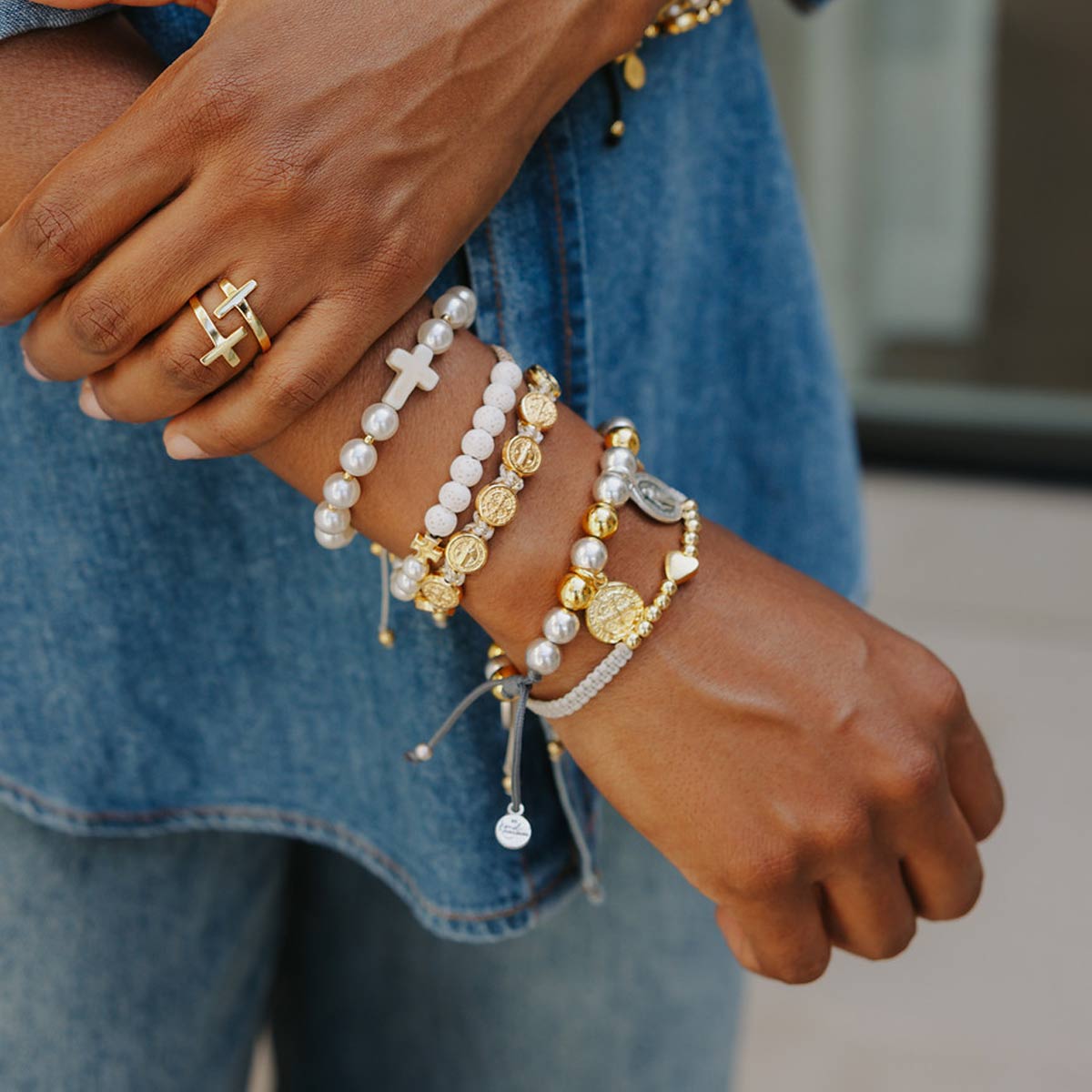 close up of woman's arm with stack of beaded and handwoven bracelets