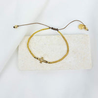Filled by Faith Bracelet with gold petite glass beads, a slipknot closure, and a gold open cross