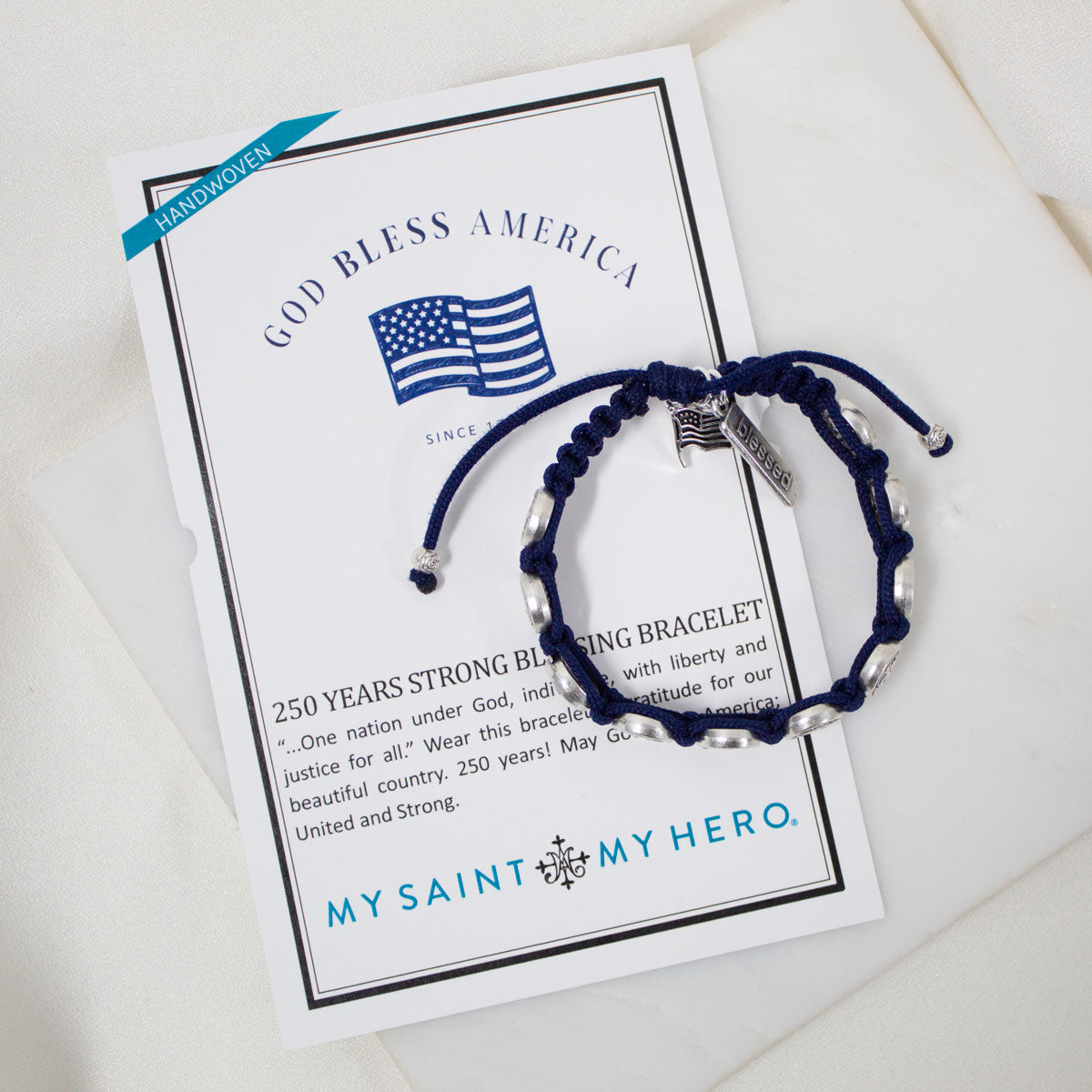 Navy blue bracelet with silver accents on a card featuring 'My Saint My Hero' branding.