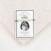 Adjustable slate grey bracelet cording with a silver-tone metal bead and a Holy Family medal, presented on a card with the text 'Christmas Miracle Holy Family.'.