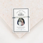 Adjustable slate grey bracelet cording with a silver-tone metal bead and a Holy Family medal, presented on a card with the text 'Christmas Miracle Holy Family.'.