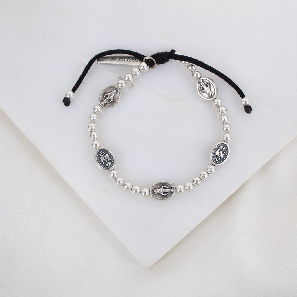 Held by Mary Silver Beads and Miraculous Mary Medal bracelet on black woven cording
