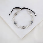 Held by Mary Silver Beads and Miraculous Mary Medal bracelet on black woven cording