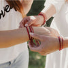 close up of the red Elevate beaded bracelets on wrists