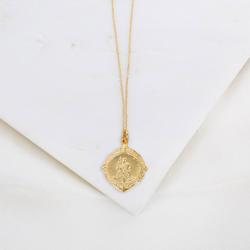 Gold necklace with a pendant on a white background