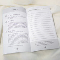 An open 40 Day Prayer Pledge Booklet showing Day 20 with reflection prompts and lined writing space, photographed on a soft white fabric background.