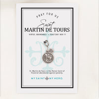 A silver St. Martin de Tour's medal charm with a crown emblem, featuring an engraved saint design and a lobster clasp, shown on a light gray background.