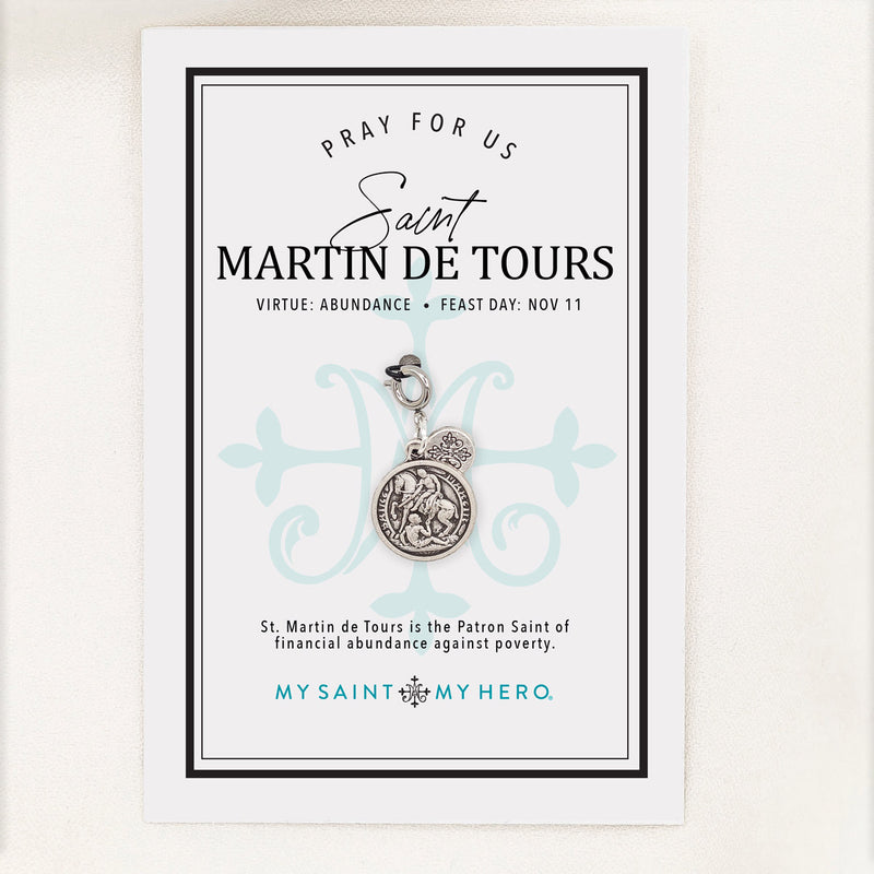 A silver St. Martin de Tour's medal charm with a crown emblem, featuring an engraved saint design and a lobster clasp, shown on a light gray background.