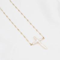 close up of a Abide Pearl Cross Necklace natural pearl