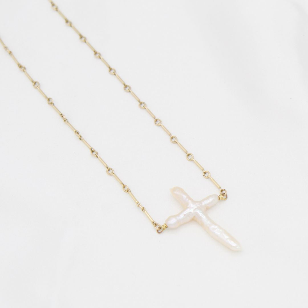 close up of a Abide Pearl Cross Necklace natural pearl