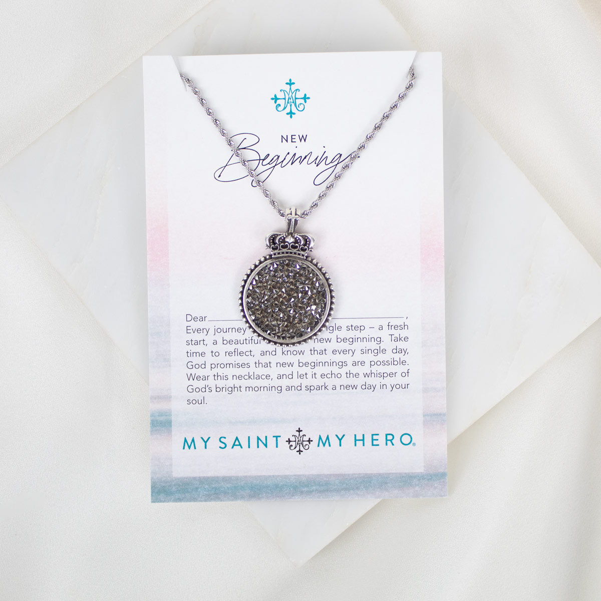 Necklace with decorative pendant on a 'My Saint My Hero' card with text