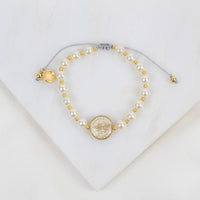 Pearl and gold beaded necklace on a white background