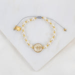 Pearl and gold beaded necklace on a white background