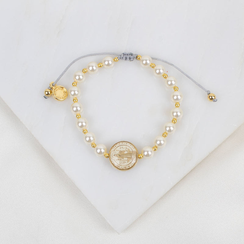 Pearl and gold beaded necklace on a white background