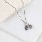 Silver necklace with two sterling silver scapular sacred heart pendant charms on a light background
