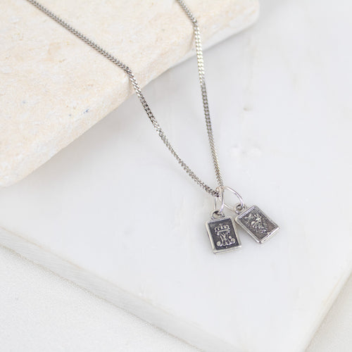 Silver necklace with two sterling silver scapular sacred heart pendant charms on a light background