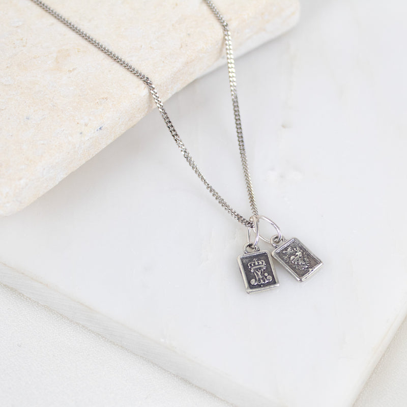 Silver necklace with two sterling silver scapular sacred heart pendant charms on a light background
