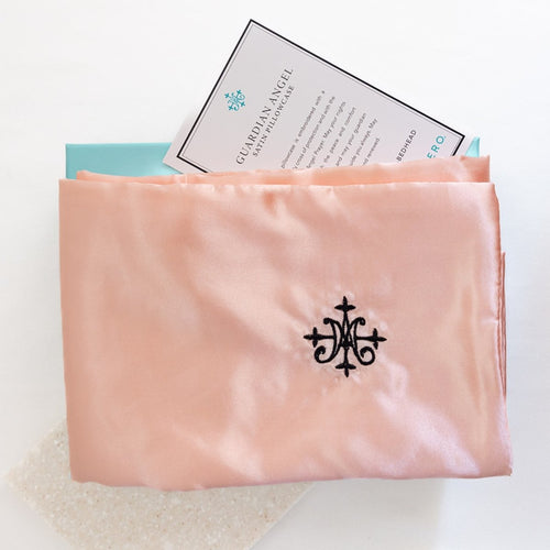 Pink satin pillowcase with a brand logo on a white background
