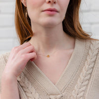 Woman wearing a petite Jesus Loves You Necklace necklace silver chain gold heart