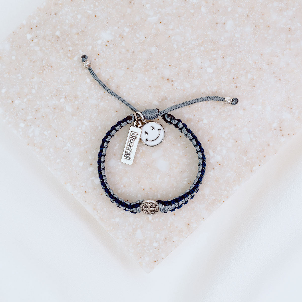 Kids Benedictine navy slate thread handwoven blessing bracelet with silver tone blessed charm and white enamel happy face