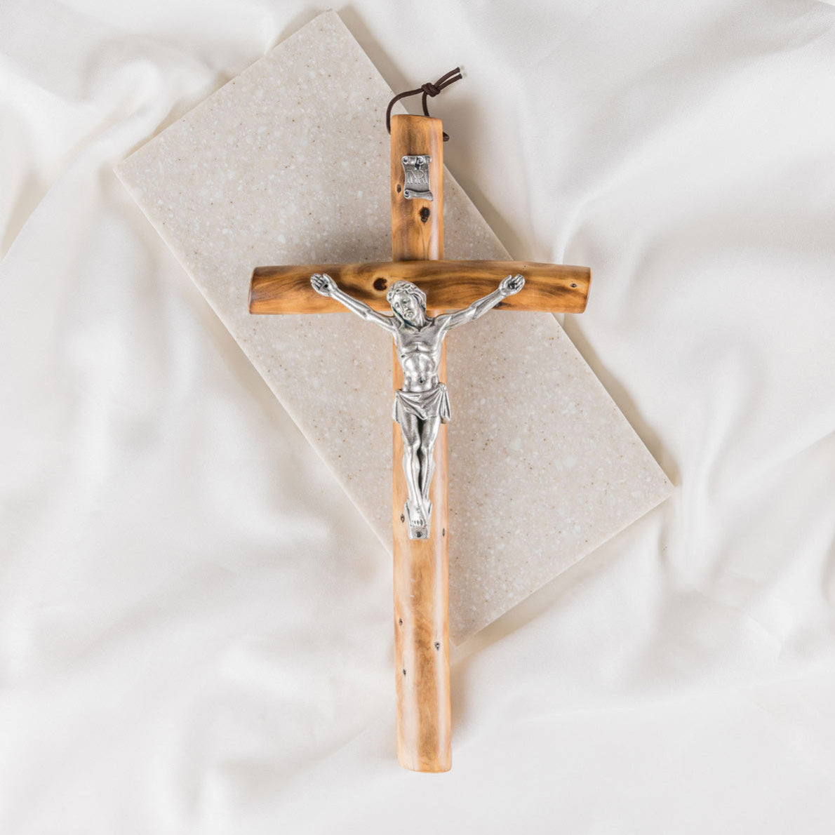 Wooden cross with silver Jesus figure on a white background