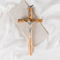 Wooden cross with silver Jesus figure on a white background
