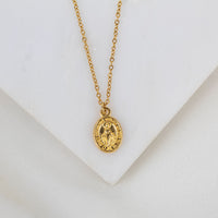 Gold necklace with a Miraculous Medal pendant on a white background