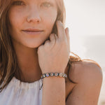 Woman in sunshine wearing white top and Wonder Crystal Bracelet