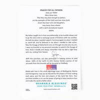 A printed prayer card for 'Prayer for All Fathers' with a handwritten signature in the center, a small illustration of a child, and donation information for Childhelp. The card is photographed on a white background with a faint watermark at the bottom.