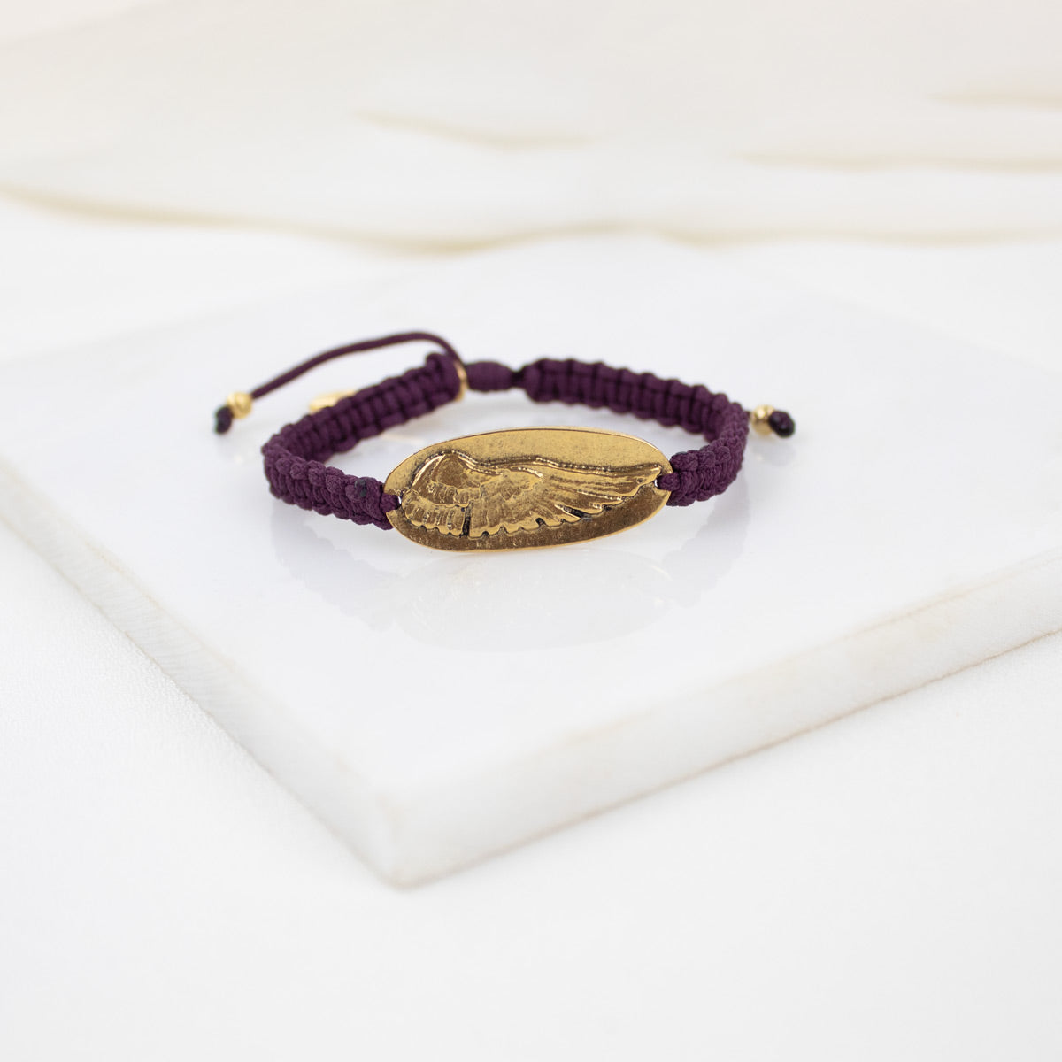 MERLOT bracelet with a gold WING MEDAL  on worven cording 