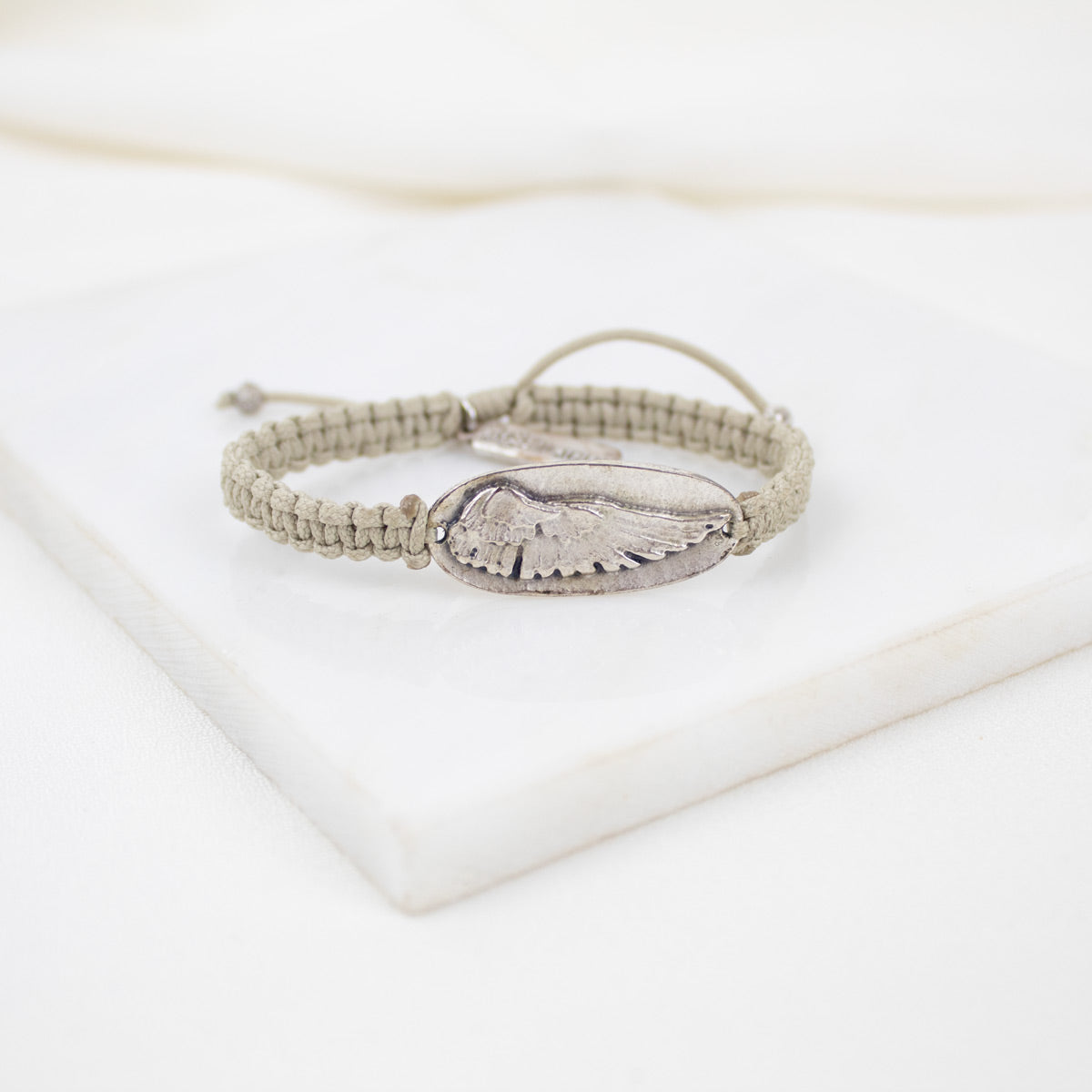 Bracelet with angel wing charm on a white background