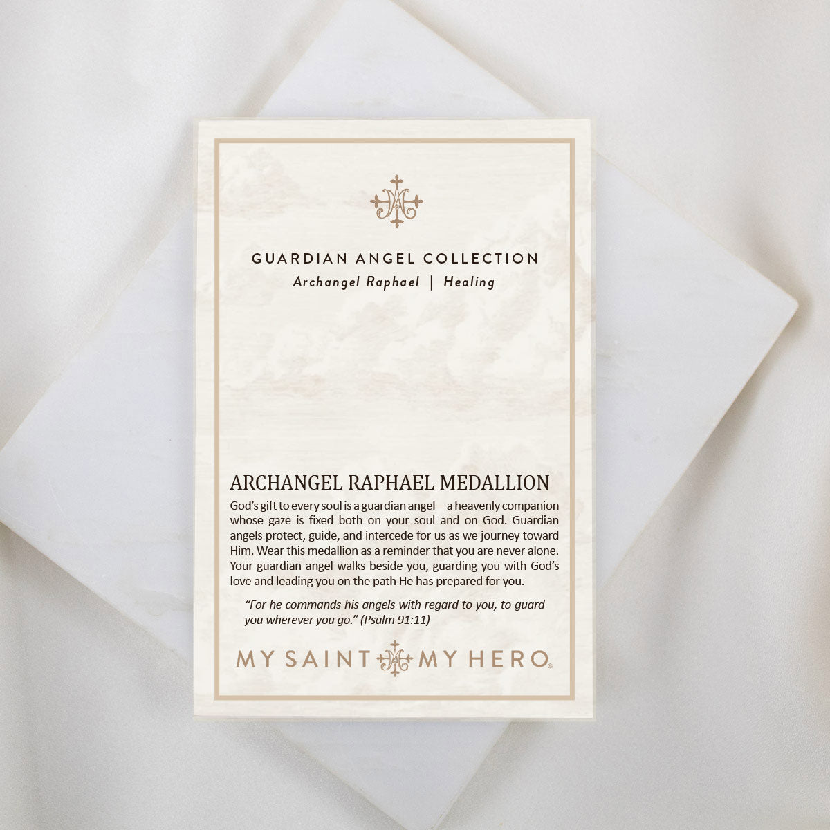 An inspirational product information card for the Archangel Raphael Guardian Angel Necklace, placed on a white marble background. The card reads "ARCHANGEL RAPHAEL" at the top, explaining that the name means "God heals," followed by the "ARCHANGEL RAPHAEL PRAYER" asking for guidance, healing, and protection. At the bottom, a "WEARABLE BLESSINGS" brand logo and a QR code are visible.