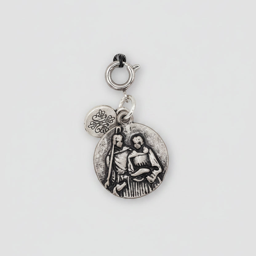 Pendant charm on a card with text about Archangel Raphael on a beige background