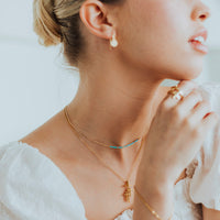 woman wearing a Blessed is She Necklace and a Faithful LIght cross necklace