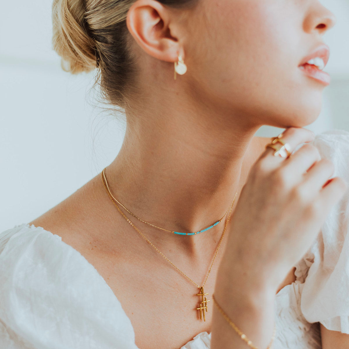 woman wearing a Blessed is She Necklace and a Faithful LIght cross necklace