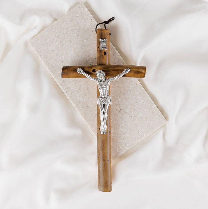 Wooden cross with a silver Jesus figure on a white background