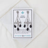 Pair of chandelier earrings on a 'My Saint My Hero' card with a white background