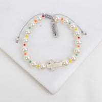 Pearl bracelet with colorful beads and 'blessed' tag on a white background