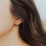 Faith Petite Cross Earrings worn by woman with brown hair