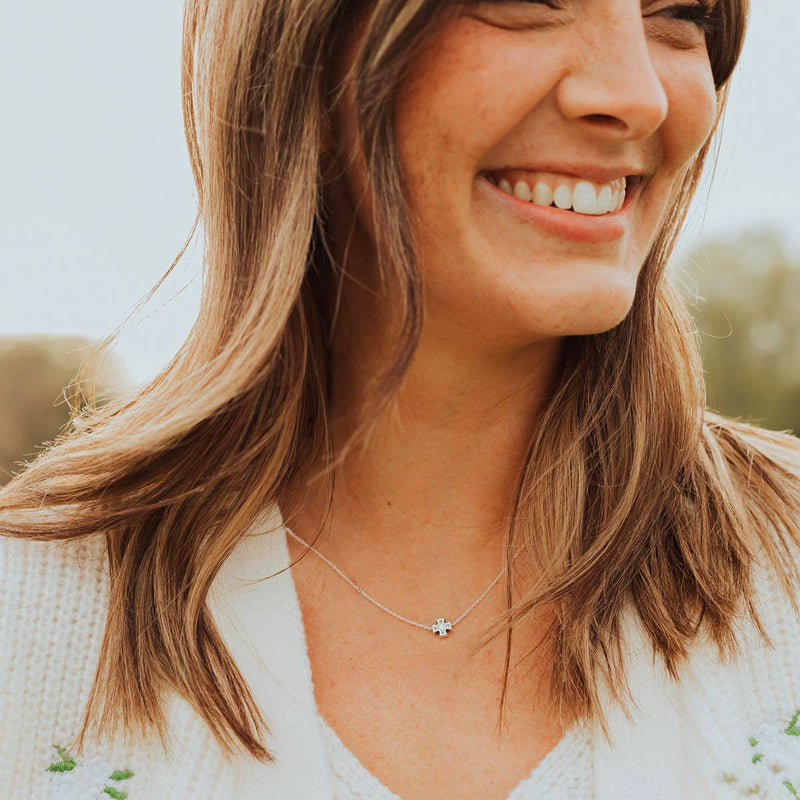 Woman smiling wearing a silver Faith Petite Cross Necklace